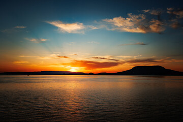 Obraz premium Abendstimmung am Bodensee mit Blick auf das Wasser und untergehender Sonne am Horizont