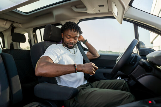 Man buckling seatbelt inside a parked car