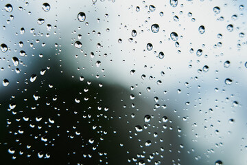 Raindrops on glass with blurred background.