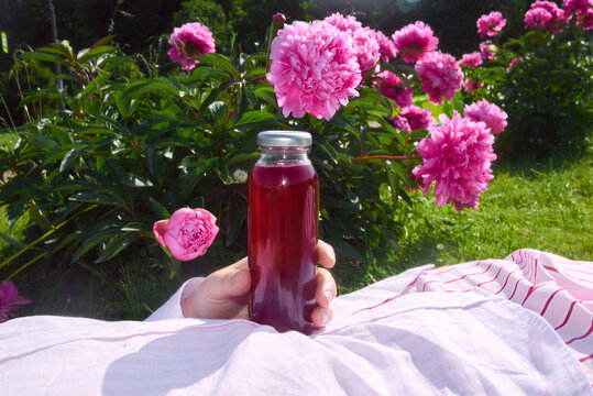 Relaxing in a flower garden with a refreshing drink on a sunny day
