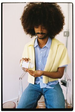 Curly Hair Man with Pills in Office