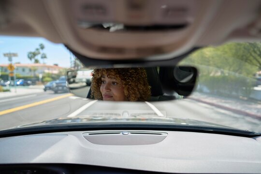 Driving in an Urban Area With a Woman in the Rearview Mirror