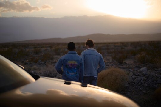 Male Friends exploring the desert during sunset in a remote area