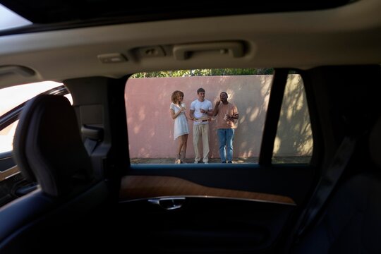 Friends enjoying a casual snack and conversation outside a vehicle