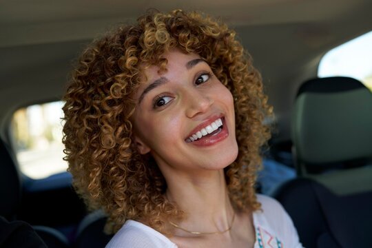 Portrait of a Smiling Woman With Curly Hair Enjoying a Ride in a Car