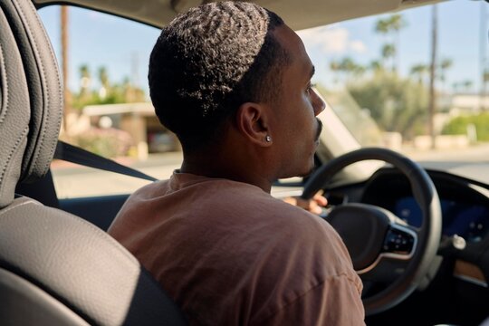 Young Man Driving in City During Sunny Afternoon