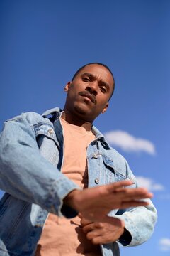 Confident Man Posing Against a Clear Blue Sky During Daytime