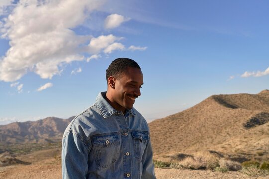 Man Enjoys Mountain View With Clouds During Daylight