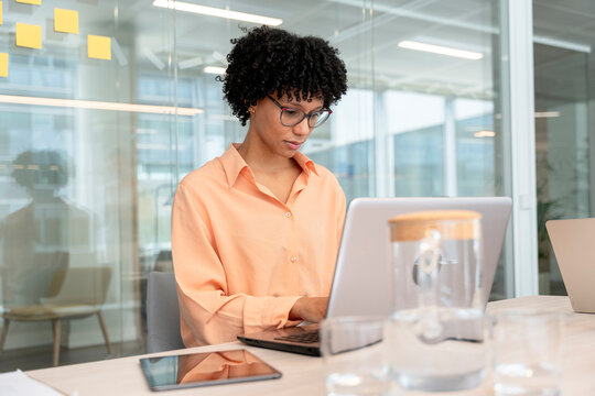 Focused businesswoman working on laptop in modern office
