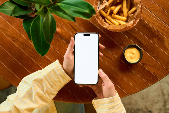 Woman's hands with a white-screen mobile phone