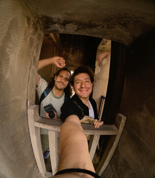 Men Smiling Inside Temple Window Frame with Camera