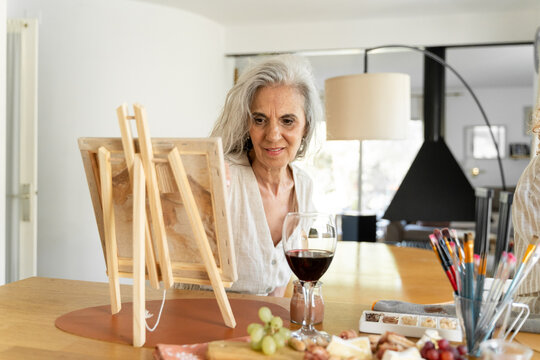 Older woman painting canvas
