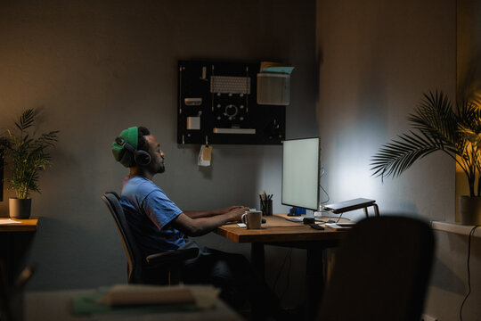 A man uses a computer with white screen at night