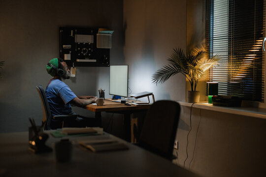 A man uses a computer with white screen at night