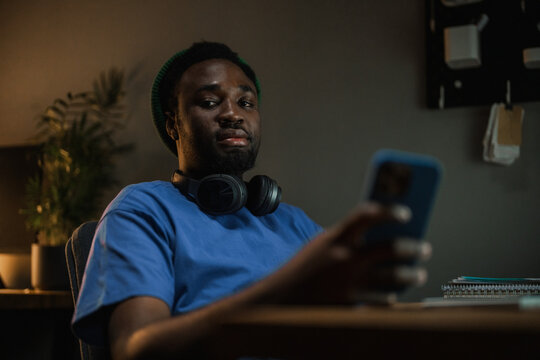 A man uses a mobile phone in the office at night