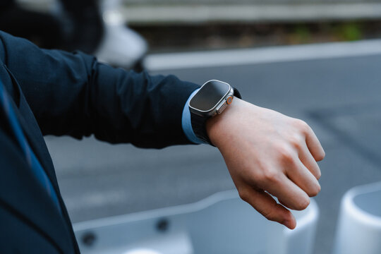 A businessman uses an electronic watch