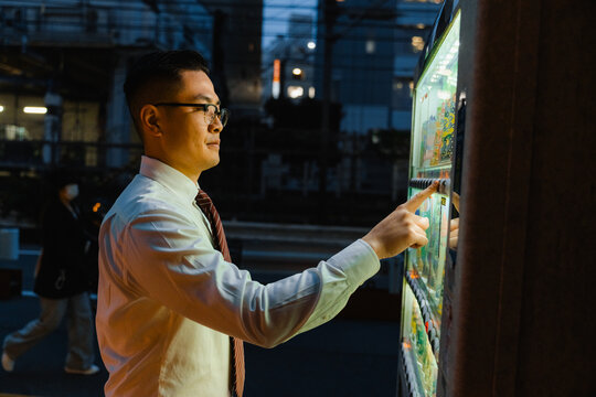 A man uses a vending machine with street food