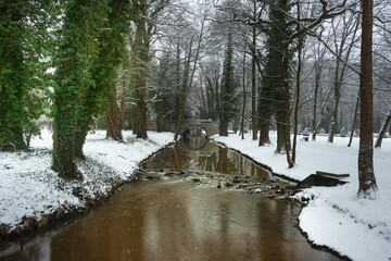 Pałac dworski w mieście Iłowa w zimowy dzień. Część japońska parku z elementami architektury parkowej w postaci lampionów, kładek, schodów, altanek, stawu parkowego i strumyka. © boguslavus