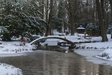 Pałac dworski w mieście Iłowa w zimowy dzień. Część japońska parku z elementami architektury parkowej w postaci lampionów, kładek, schodów, altanek, stawu parkowego i strumyka. © boguslavus