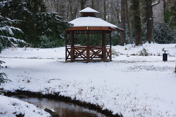 Pałac dworski w mieście Iłowa w zimowy dzień. Część japońska parku z elementami architektury parkowej w postaci lampionów, kładek, schodów, altanek, stawu parkowego i strumyka. © boguslavus