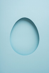 Happy vertical Easter greeting featuring a paper egg cutout on a pastel blue minimal background, ideal for cards, templates and spring celebration designs and mockups © ActionGP