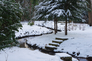 Pałac dworski w mieście Iłowa w zimowy dzień. Część japońska parku z elementami architektury parkowej w postaci lampionów, kładek, schodów, altanek, stawu parkowego i strumyka. © boguslavus