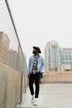 Young Man Walks Towards Camera on Downtown Rooftop