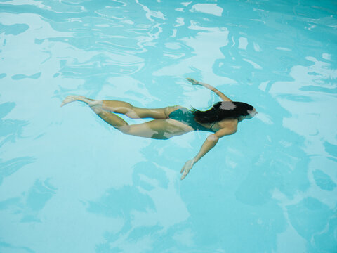 Woman Swimming Gracefully in a Clear Blue Pool
