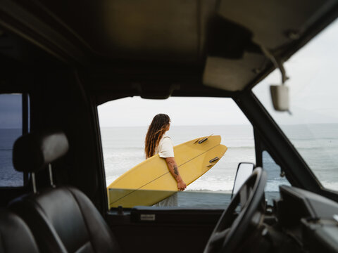 Surfer Aims to Ride Waves at Morning Beach