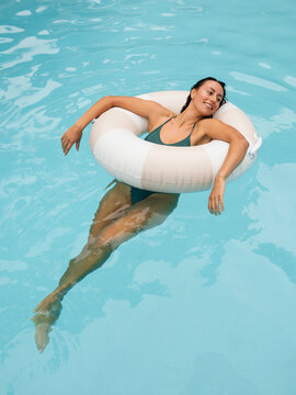 Woman Enjoys Relaxation While Floating in a Pool