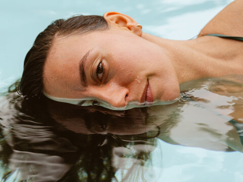 Woman Relaxing in Pool Water With Serene Expression