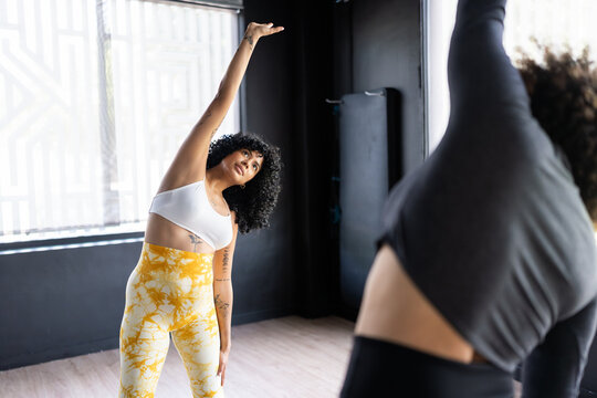Two women stretching bodies during dance class in studio