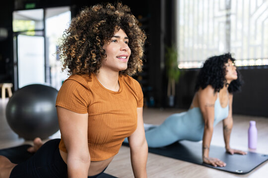 Young women practicing upward dog pose in yoga class