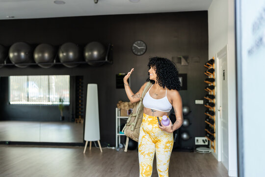 Sporty woman waving goodbye at the gym after her workout