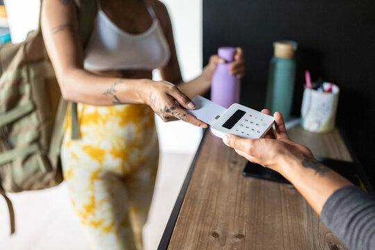 Customer paying with credit card using NFC technology in a gym