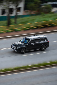 Black Mercedes-Benz GLS side view in movement, Luxury full-size SUV cruising city highway