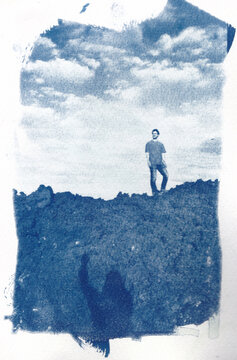 Cyanotype of  on rocky surface with cloudy sky