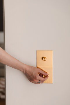 Adjusting Golden Dimmer Switch in Modern Interior