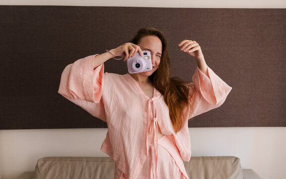 Joyful Woman with Instant Camera at Home