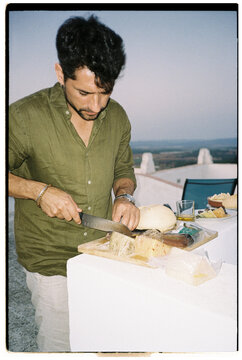 Man Slicing Cheese Outdoors