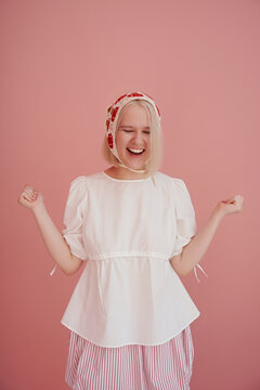 Young woman with joyful expression against pink background