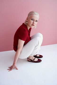 Model poses elegantly against a pink background