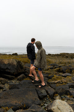 Father and son exploring the shore on a misty day