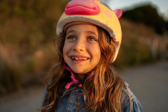 Joyful Girl at Sunset in Unicorn Helmet