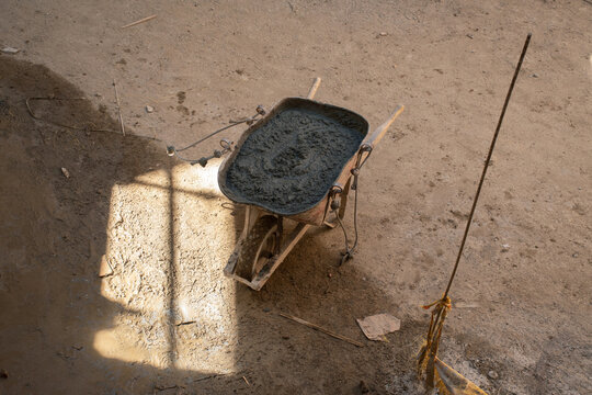 Wheelbarrow filled with fresh concrete on construction site