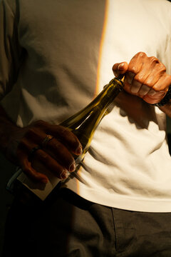 Close Up and Black Man's Hands As He Opens a Bottle of Wine