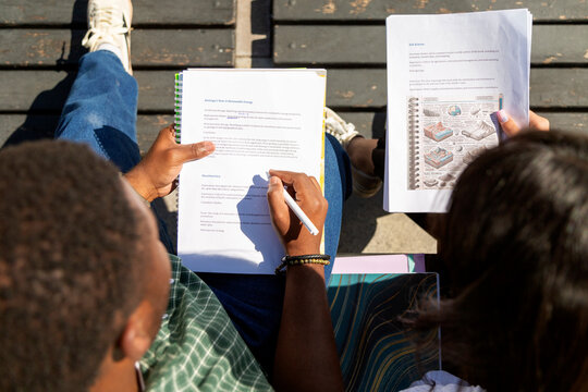 Students reviewing geology notes outdoors on campus