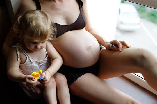 pregnant mother and child spending time at home