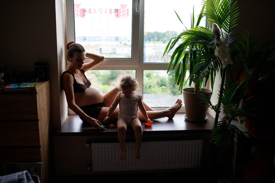 pregnant mother and child spending time at home