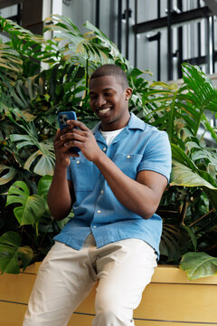 Young Man Sitting and Using Phone
